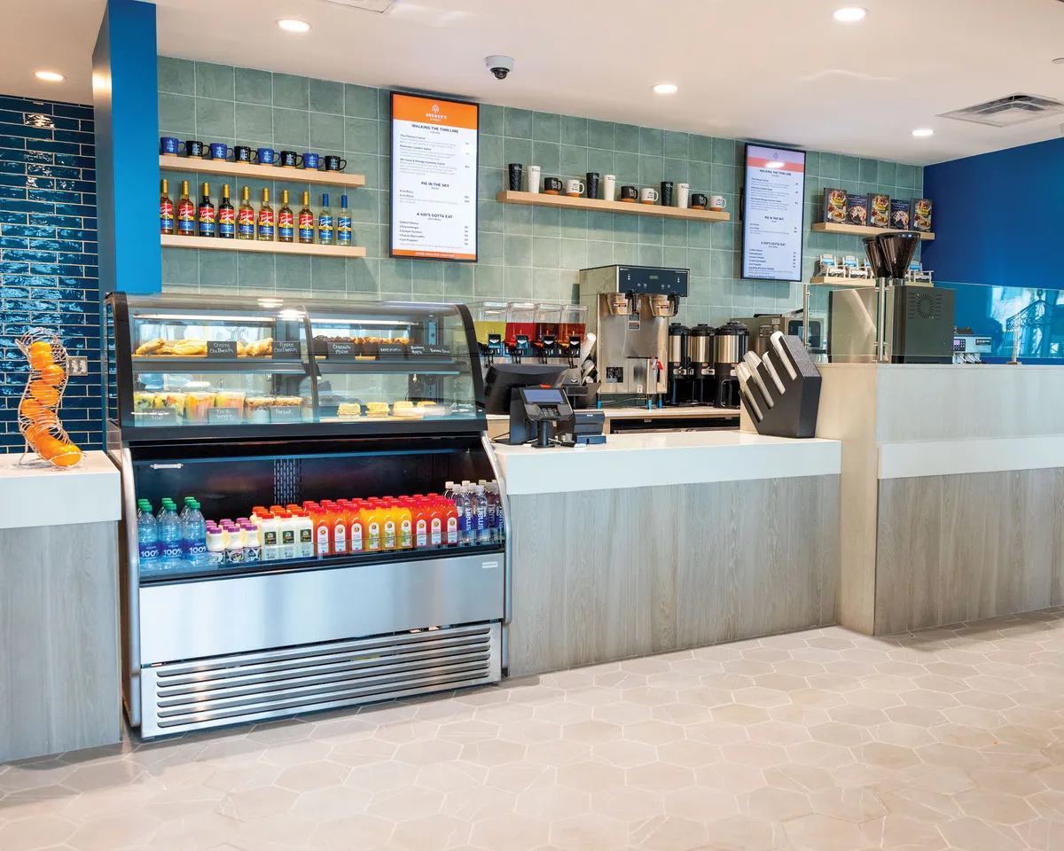 A vibrant interior view highlighting a coffee machine, display case filled with pastries, beverage cooler, and menu boards. The scene is lively and energetic, ideal for casual conversations and sharing refreshments.