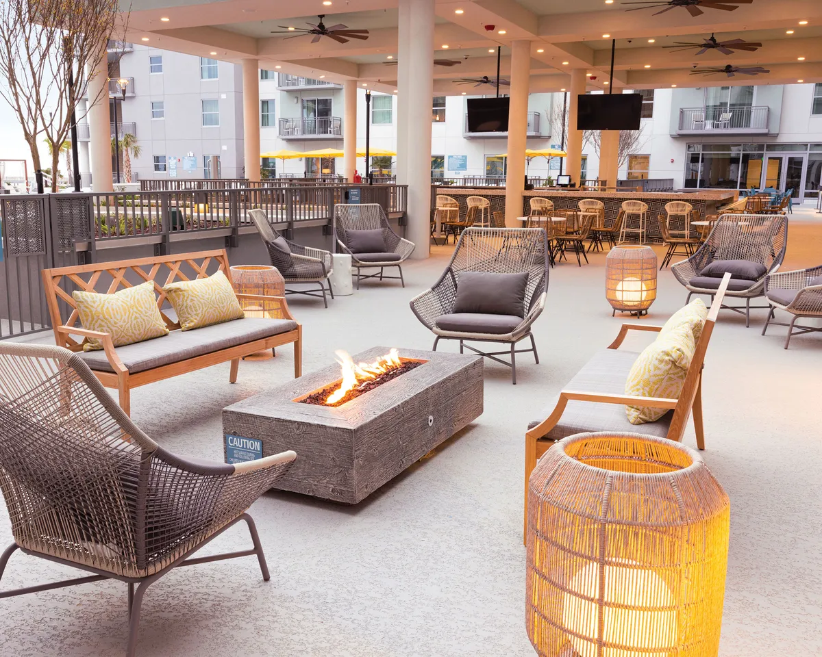 An inviting fire pit area with comfortable seating and decorative lanterns sets the scene for cozy evenings. The glow of the fire creates a welcoming spot for socializing, relaxing, and enjoying celebrations under the stars.
